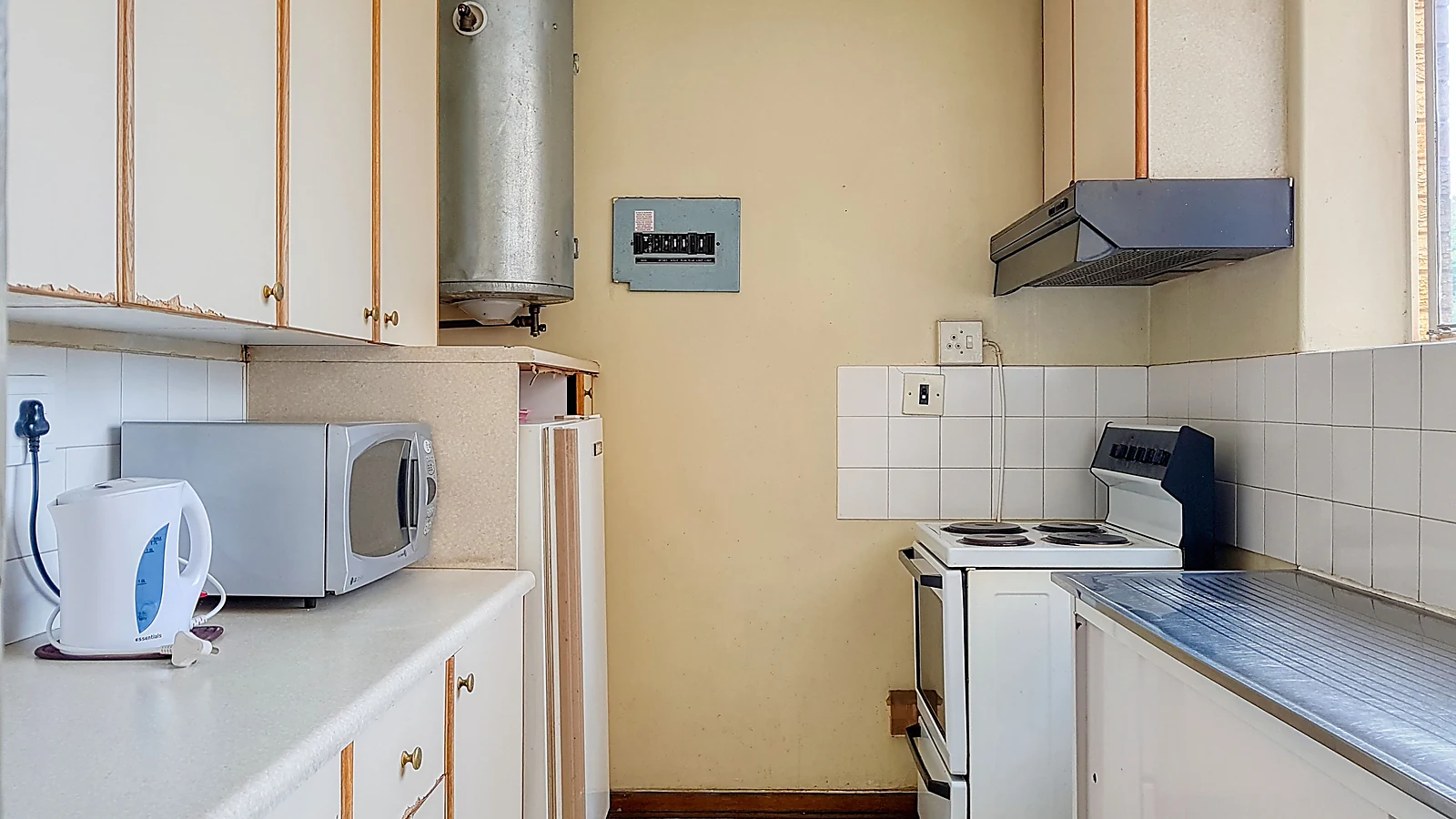 Dapur kecil dengan area memasak menyiapkan bahan dan mencuci yang tertata